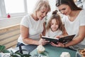 Fast learning kid. Mother, grandmother and daughter having good time in the kitchen