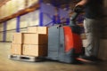 Fast Motion of Workers Unloading Package Boxes on Pallets in Storage Warehouse. Electric Forklift Pallet Jack Loader Royalty Free Stock Photo