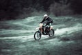 Fast motocross dirtbike rider on sand