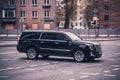 Fast moving black Cadillac Escalade ESV on highway road. Overspeed in city concept. SUV car on city road in motion, side view Royalty Free Stock Photo