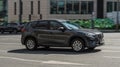 Fast moving black Mazda CX5 on city road. Compliance with speed limits on the streets. Front side view shot of driving SUV