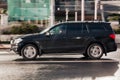Fast moving black Mercedes-Benz GL SUV on highway road. Overspeed in city concept. Premium car on city road in motion, side view