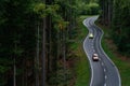 Top view of a moving cars with motion blur effect. Transport on a forest road in summer