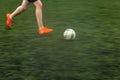 Fast moving feet of a soccer player on a pitch during a match