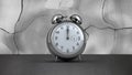 Fast moving hands and alarm bells ringing on silver alarm clock on distorting grey background