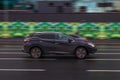 Fast moving Nissan Murano Z52 on the city road. Black SUV driving on motorway. Used auto in fast motion with blurred background