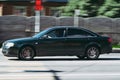 Fast moving old audi A6 C5 car on the city road. Speeding in the city concept. Green auto in fast motion with blurred background