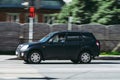 Fast moving old Cherry Tiggo on the city road. Black SUV with man driving. Used auto in fast motion with blurred background.