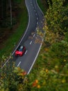 Fast moving red sport car with motion blur effect. Transport on a forest road in summer. Top view from above. Royalty Free Stock Photo