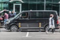 Fast moving Volkswagen Transporter T6 on the city road. Black van rides on street. Commercial auto in fast motion with blurred Royalty Free Stock Photo