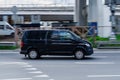 Fast moving Volkswagen Transporter T6 on the city road. Black van rides on street. Commercial auto in fast motion with blurred Royalty Free Stock Photo