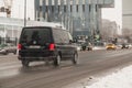 Fast moving Volkswagen Transporter T6 on winter city road. Black van rides on wet slippery street. Commercial auto in fast motion Royalty Free Stock Photo