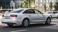 Fast moving white car with motion blur effect. overspeed concept. Modern Audi A6 auto goes fast on the road Royalty Free Stock Photo