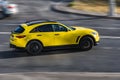 Fast moving yellow Infiniti QX70 S car on highway road. Overspeed in city concept. SUV car on city road in motion, side view Royalty Free Stock Photo