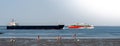 A fast passenger ferry connecting the island Helgoland and Hamburg is overtaking a freighter on the river Elbe.