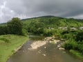 A fast river flowing from the mountains among the stones and a settlement in the mountains