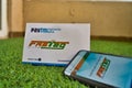 Fast Tag provided by PayTM Payment Bank on green grass with a mobile phone logged into fast tag website