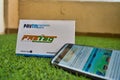 Fast Tag provided by PayTM Payment Bank on green grass with a mobile phone logged into fast tag website