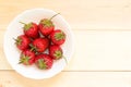 Fast vegan snack from fresh delicious strawberries in white bowl on wooden table with copy space. Top view. Royalty Free Stock Photo