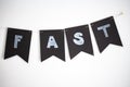 Fast word letters written on black flags on a white wall background