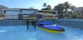 A fast yellow and blue motorboat is moored to the concrete pier of an advanced high-tech home.