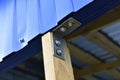 Fasteners of a wooden structure with the help of an iron corner and self-tapping screws Royalty Free Stock Photo