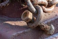 Fastening the chain with a large bolt. At the end of the chain is an old rusty bolt. Securing the ship with a large chain. Old