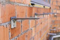 Fastening for insulation on a brick wall of a house under construction. Installation of fittings for fastening. Selective focus Royalty Free Stock Photo