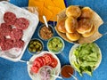 Fastfood, burger party concept. Various delicious burgers set with french fries and sauces on bright blue background Royalty Free Stock Photo