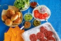 Fastfood, burger party concept. Various delicious burgers set with french fries and sauces on bright blue background Royalty Free Stock Photo