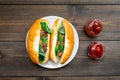 Fastfood concept. Make fresh hotdogs and home. bun for hot dogs with freid sausages and basil near tomato sause on dark Royalty Free Stock Photo