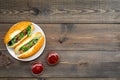 Fastfood concept. Make fresh hotdogs and home. bun for hot dogs with freid sausages and basil near tomato sause on dark Royalty Free Stock Photo