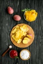 Cooking homemade potato chips with ketchup on wooden background top view Royalty Free Stock Photo