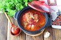 Fasting food. Vegetable soup with sauerkraut, beetroot, carrots, onions, tomato in a black pot on a wooden background Royalty Free Stock Photo