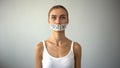 Fasting word written on taped mouth of upset anorexic model, self-destruction