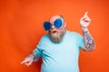 Fat amazed man with beard, tattoos and sunglasses dances music Royalty Free Stock Photo