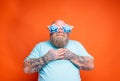 Fat amazed man with beard, tattoos and sunglasses is surprised for something