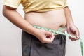 Fat asia girl with overweight checking out his weight, hand holding measurement tape on her belly fat.woman diet lifestyle and Royalty Free Stock Photo