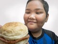 Fat Asian boy enjoys fast food Royalty Free Stock Photo