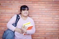 A fat Asian woman carrying a textbook and carrying a bag. Royalty Free Stock Photo