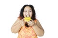 Fat Asian woman eating a smiley doughnut Royalty Free Stock Photo