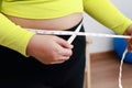 Fat Asian woman exercising at home using meter tape. Royalty Free Stock Photo