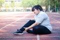 Fat Asian woman injured from jogging Sitting on the floor, holding the right ankle, felt a lot of pain.