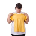 Fat asian woman trying to wear small size of yellow t-shirt isolated on white. Fat and Healthcare concept Royalty Free Stock Photo