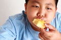 Fat boy eating bread Dough too much to eat, not good for health. Royalty Free Stock Photo