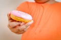 The fat boy held a donut coated with pink strawberries. Royalty Free Stock Photo