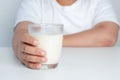 Fat boy holding a full glass of milk. Children are drinking milk.