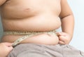 Fat boy measuring his belly with measurement tape Royalty Free Stock Photo