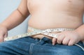 Fat boy measuring his belly with measurement tape Royalty Free Stock Photo