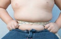 Fat boy measuring his belly with measurement tape Royalty Free Stock Photo